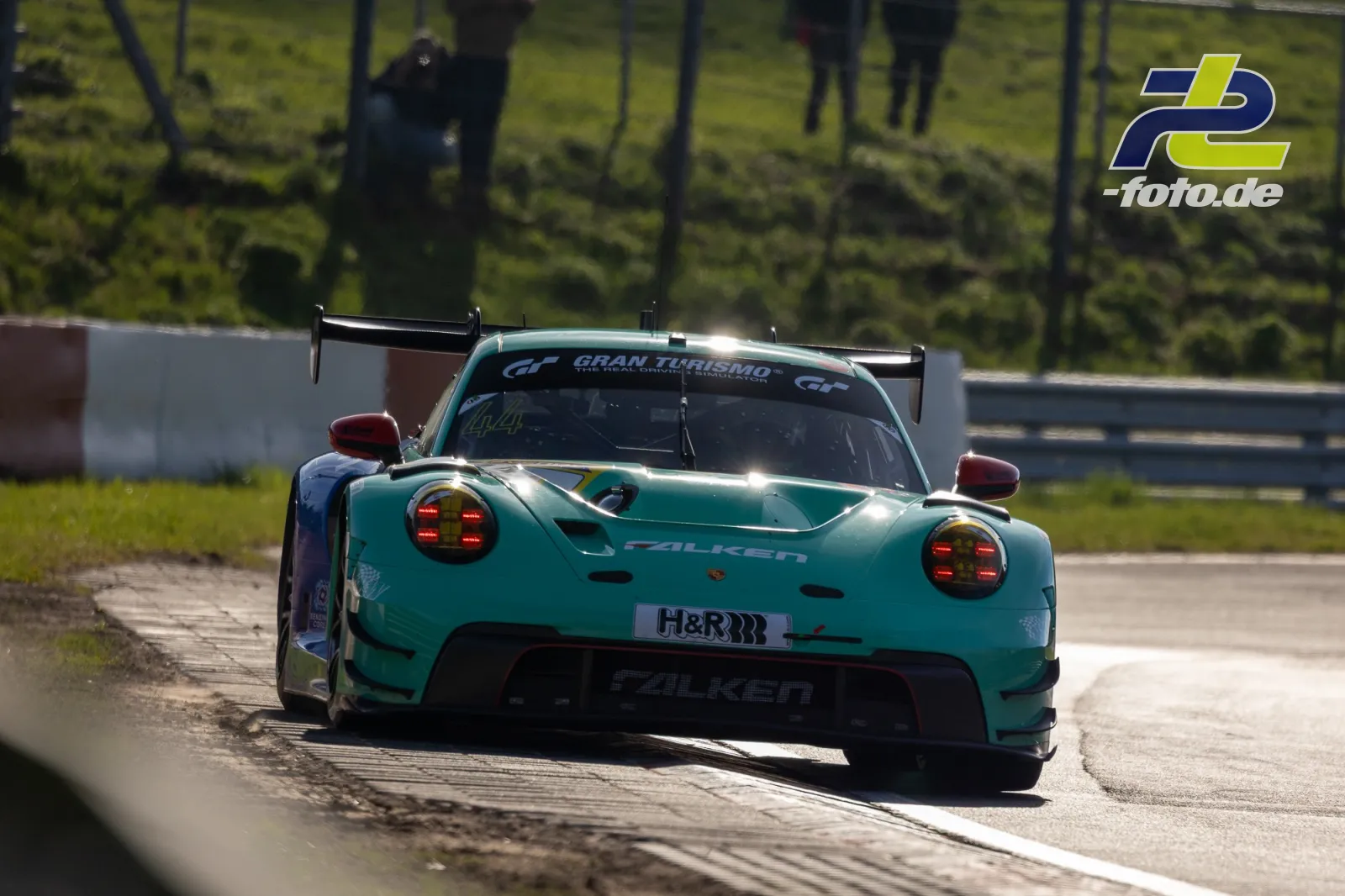 Türkisfarbener Porsche 911 GT3 mit Falken-Lackierung während des Zeittrainings auf dem Nürburgring in der Kurve.