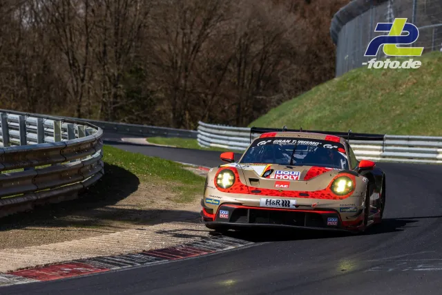 Porsche 911 GT3 R in gold-roter LIQUI MOLY Lackierung in einer Kurve der Nürburgring-Nordschleife bei Tageslicht.