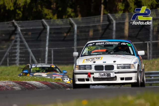 Weißer BMW E36 mit Startnummer 622 in Kurve auf Nordschleife, gefolgt von weiterem Fahrzeug, NLS-Rennen am Nürburgring