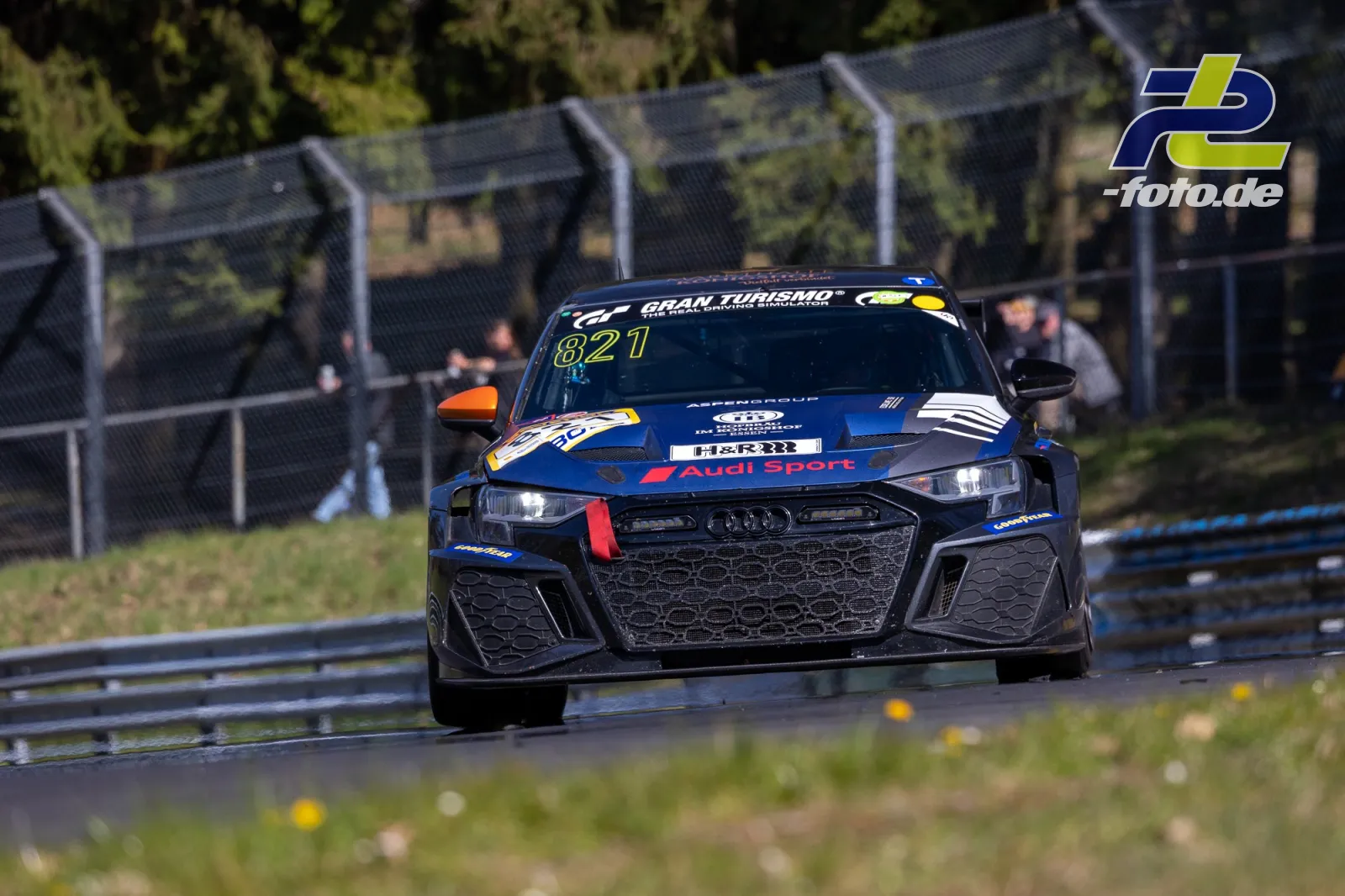 Audi Rennwagen #821 in Blau-Schwarz auf der Nürburgring Nordschleife beim NLS-Rennen, Frontalansicht in einer Kurve.