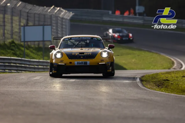 Porsche 911 GT3 Cup in gelb-schwarzer Lackierung auf der Nürburgring Nordschleife, verfolgt von einem weiteren Rennwagen