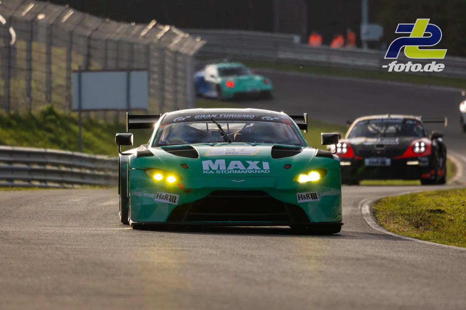 Türkisgrüner Aston Martin Vantage GT3 mit MLV-Lackierung in Frontansicht auf dem Nürburgring, gefolgt von weiteren GT3-Rennwagen.