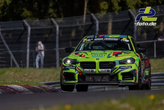 BMW M4 GT4 in grüner Lackierung mit Startnummer 877 auf der Nordschleife während des NLS-Rennens.