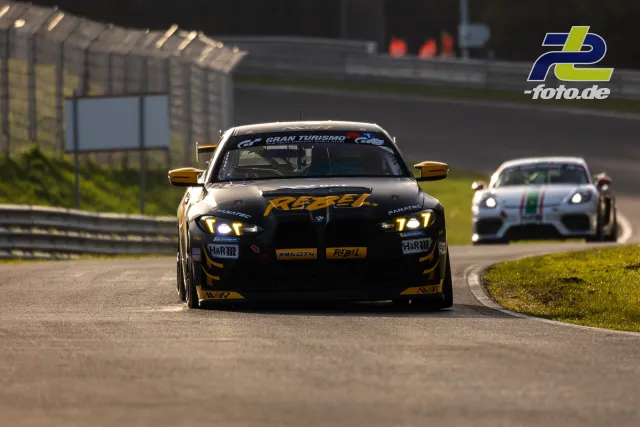 Schwarzer BMW mit gelben Akzenten während Zeittraining auf Nürburgring-Nordschleife, gefolgt von weißem Fahrzeug