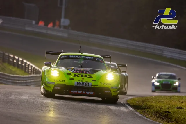 Neongelber Porsche 911 GT3 R mit Red Bull-Sponsoring in der Kurve auf dem Nürburgring, gefolgt von einem weiteren Fahrzeug.