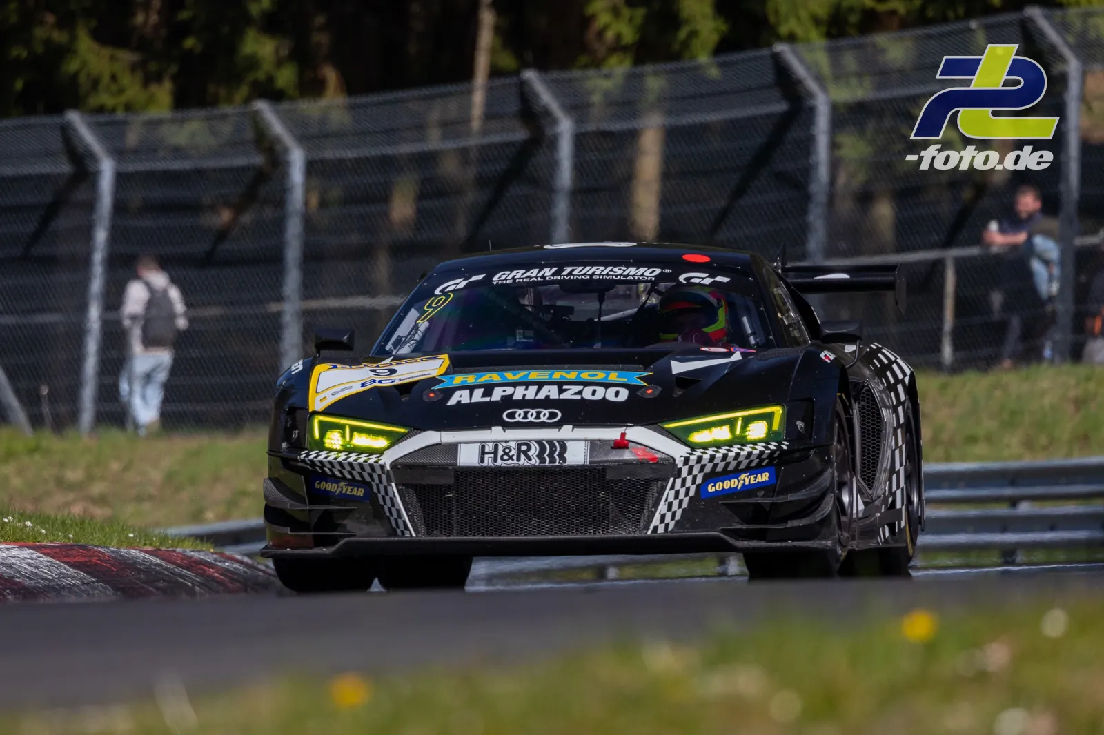 Audi R8 LMS GT3 mit schwarz-gelber Ravenol-Alphazoo-Lackierung in der Kurve auf dem Nürburgring während des NLS-Rennens.