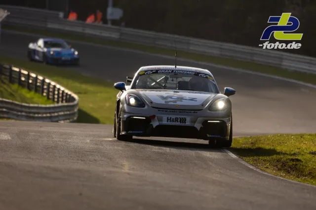 Porsche Cayman GT4 mit eingeschaltetem Licht in Kurve auf der Nordschleife, zweites Fahrzeug im Hintergrund