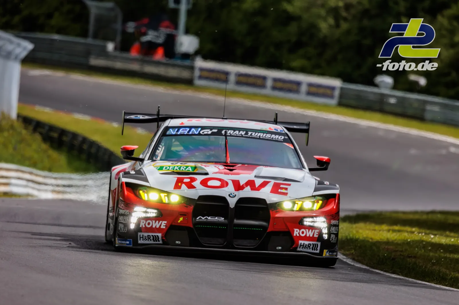 BMW M4 GT3 mit ROWE-Lackierung auf der Nordschleife während des Qualifyings zum 24h-Rennen Nürburgring mit eingeschalteten Scheinwerfern.