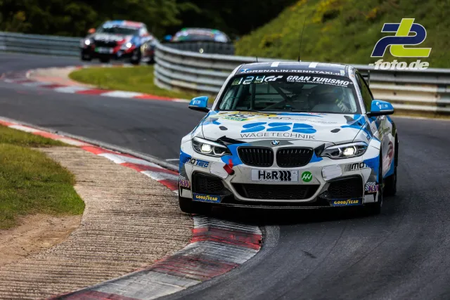 BMW-Rennwagen auf der Nordschleife beim 24h-Rennen Nürburgring, zwei weitere Fahrzeuge im Hintergrund.