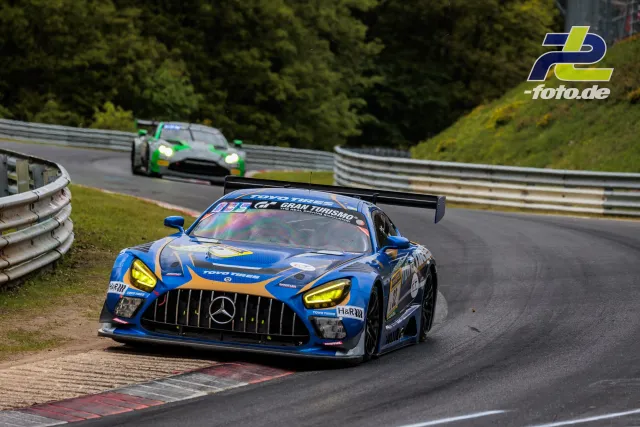 Blauer Mercedes-AMG GT3 führt vor grünem Fahrzeug durch eine Kurve beim 24h-Rennen Nürburgring