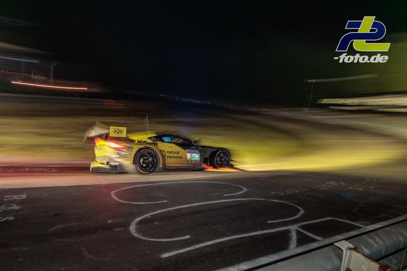 Aston Martin Vantage AMR GT3 EVO in Fahrt bei Nacht mit Funkenflug, Mitzieher während des 24h-Rennens am Nürburgring
