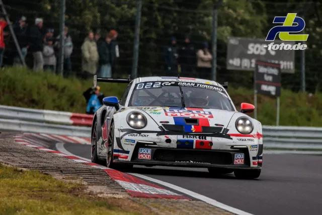 Porsche 911 GT3 R mit Liqui Moly-Lackierung auf der Nordschleife während des 24h-Rennens, Zuschauer am Streckenrand.