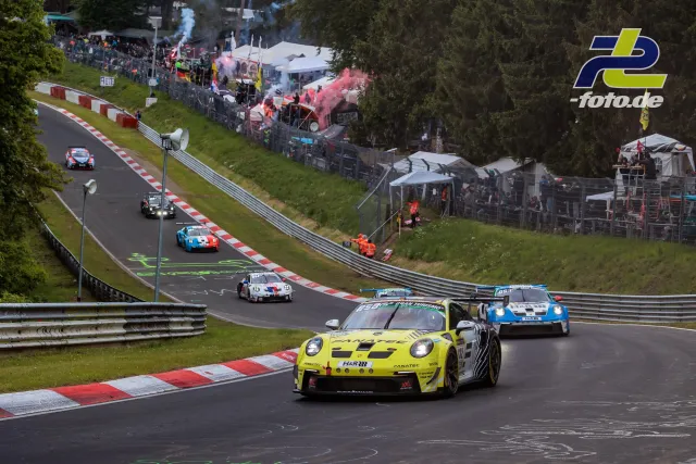 Mehrere GT3-Fahrzeuge in der Formationsrunde auf der Nordschleife mit Zuschauern und Rauchfahnen im Hintergrund