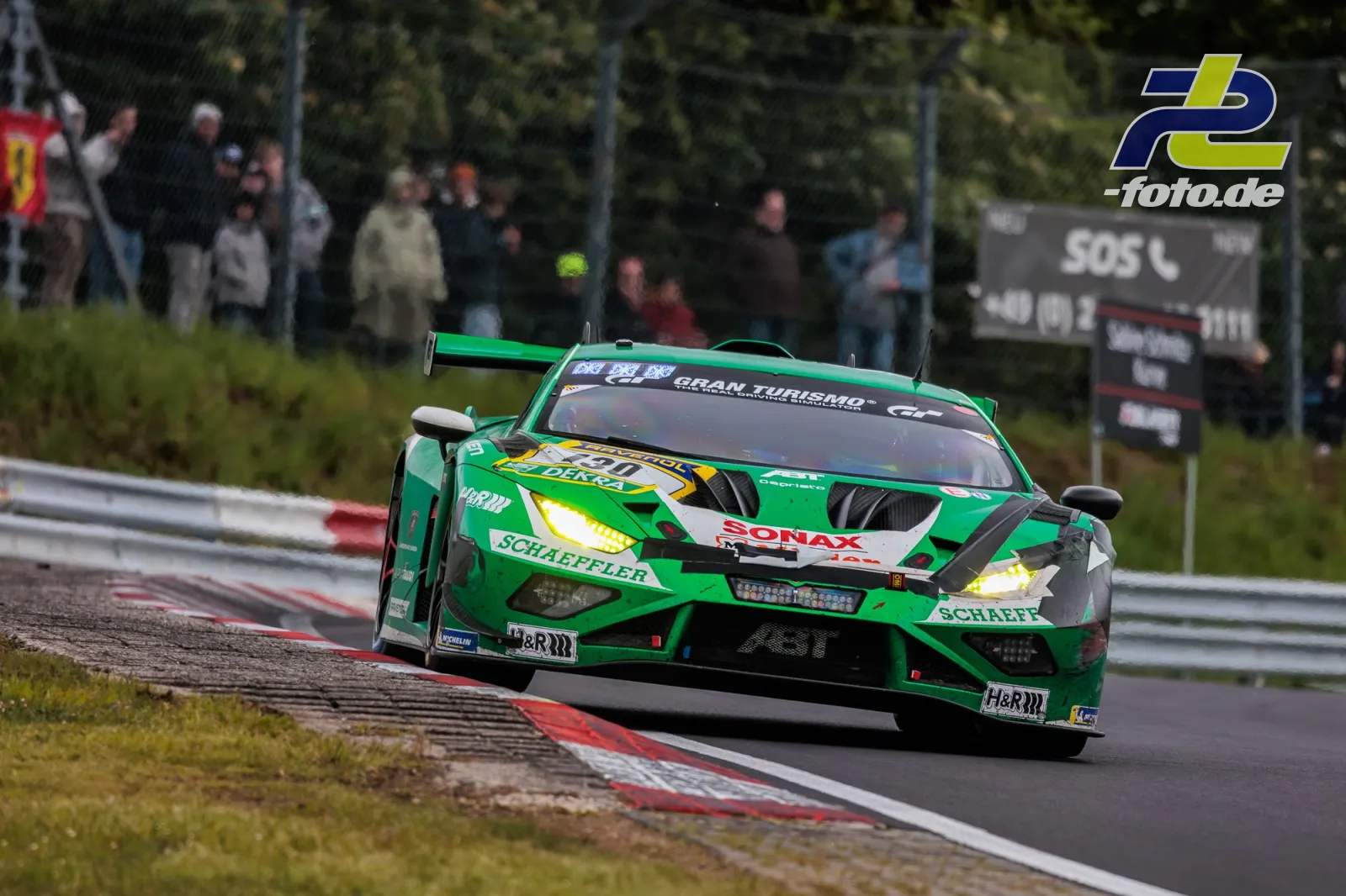 Lamborghini Huracan GT3 EVO2 #130 vom Red Bull Team ABT in Kurve auf dem Nürburgring beim 24h-Rennen, Zuschauer im Hintergrund.