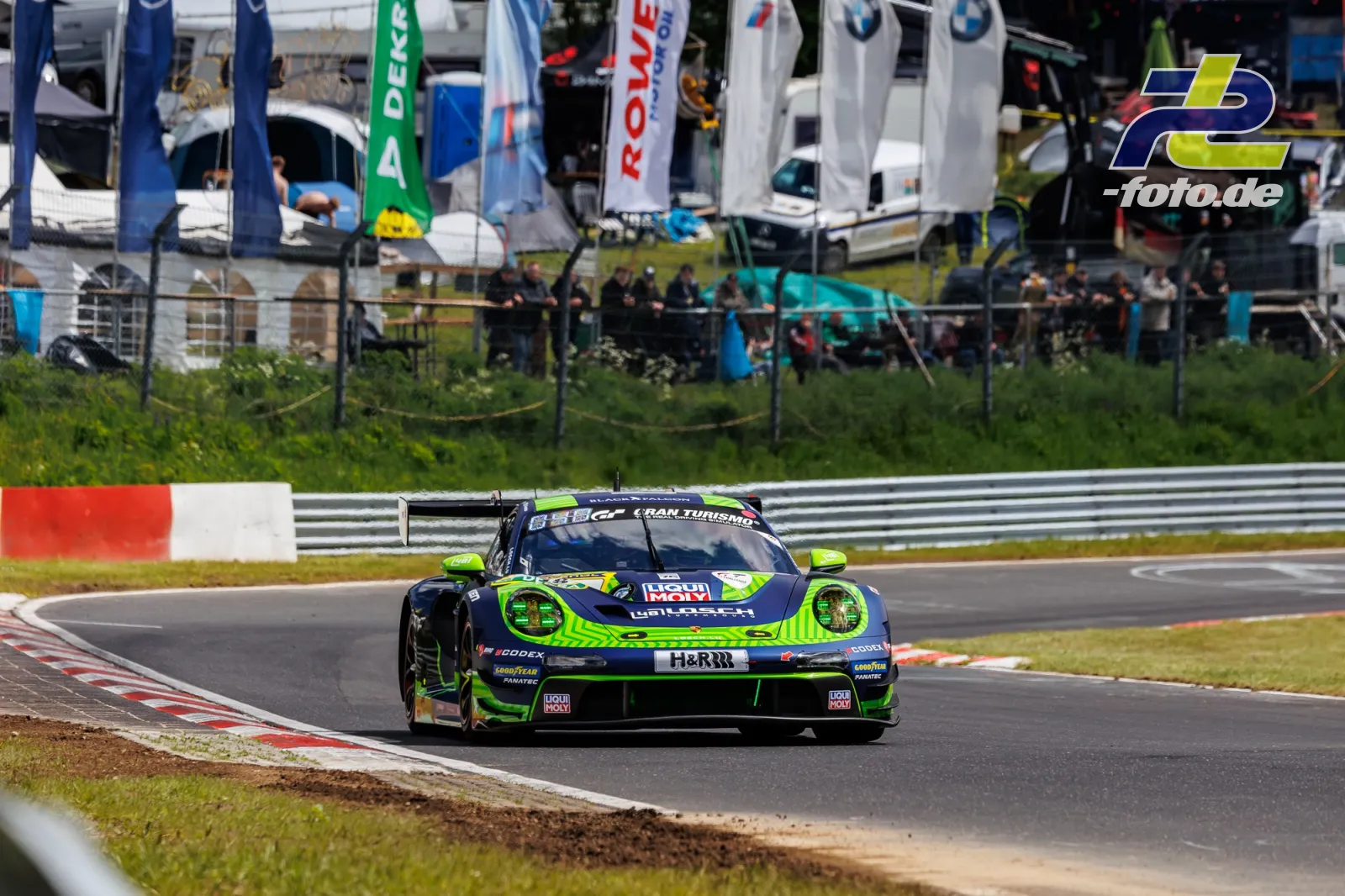 Porsche 911 GT3 R Nummer 1 in dunkelblau-neongrüner Lackierung während Qualifying 1 auf der Nordschleife beim 24h-Rennen Nürburgring.