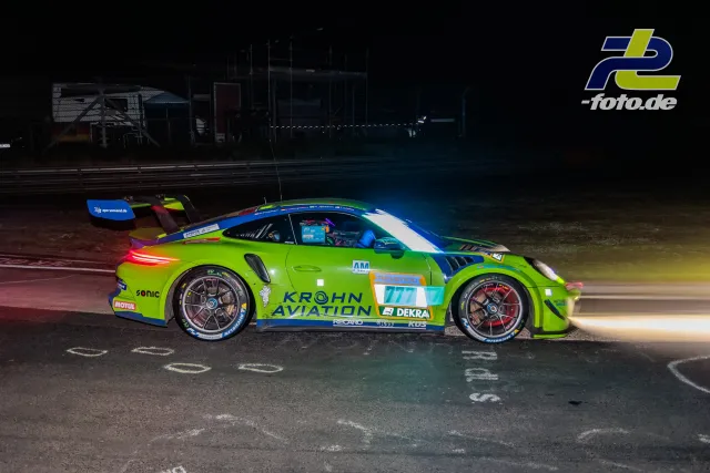 Porsche 911 GT3 R #777 in grüner Lackierung bei Nachtfahrt auf dem Nürburgring während des 24-Stunden-Rennens.
