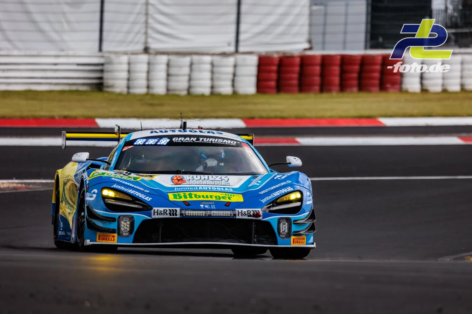 McLaren 720S GT3 in blau-gelber Lackierung während des Qualifyings auf dem Nürburgring, frontal auf der Strecke.