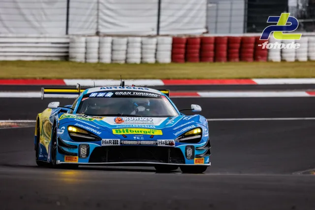 McLaren 720S GT3 in blau-gelber Lackierung während des Qualifyings auf dem Nürburgring, frontal auf der Strecke.