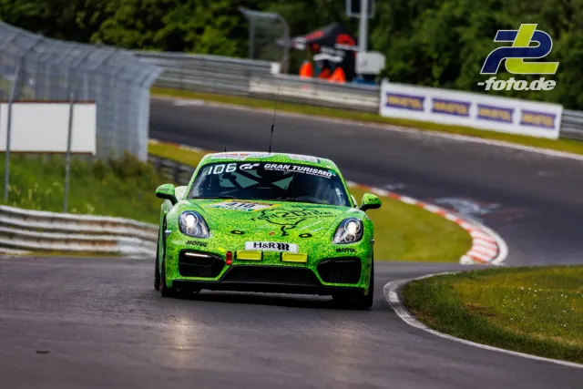 Leuchtend grüner Porsche Cayman in Kurve auf der Nordschleife während des Qualifyings zum 24h-Rennen am Nürburgring.