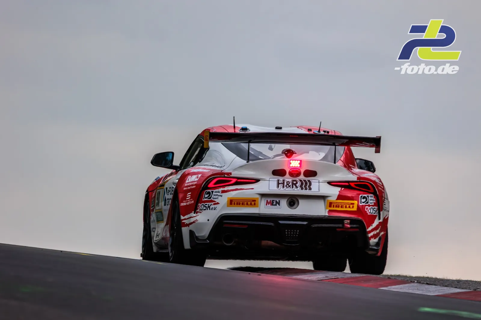 Toyota GR Supra GT4 EVO2 von Teichmann Racing fährt über eine Kuppe am Nürburgring während des 24h-Rennens, Heckansicht.