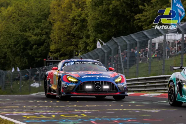 Mercedes-AMG GT3 in AMG-Lackierung auf der Nürburgring-Nordschleife während des 24h-Rennens, im Hintergrund weitere Fahrzeuge und Zuschauer.