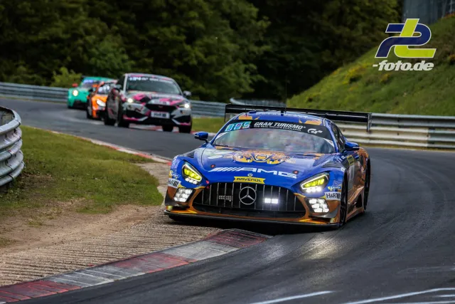 Mercedes-AMG GT3 in blau-orange mit Startnummer 80 auf der Nordschleife, dahinter drei weitere Rennwagen im Feld.