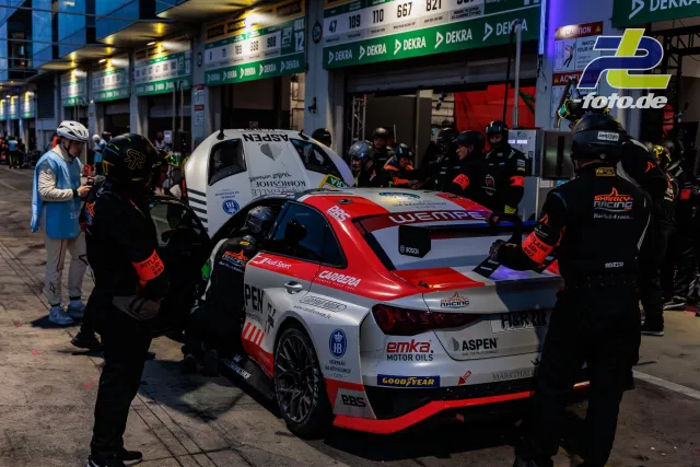 Boxenstopp eines Audi RS3 LMS SEQ in der Boxengasse während des 24h-Rennens am Nürburgring, Mechaniker arbeiten am Fahrzeug.