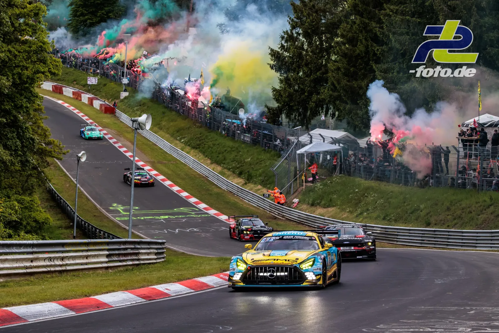 Mercedes-AMG GT3 in Formationsrunde am Nürburgring mit bunten Rauchfackeln der Zuschauer entlang der Nordschleife