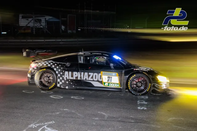 BMW M4 GT3 mit ALPNAZOO-Lackierung bei Nacht im Mitzieher während des 24h-Rennens am Nürburgring, Bewegungsunschärfe durch vorbeifahrendes Auto.