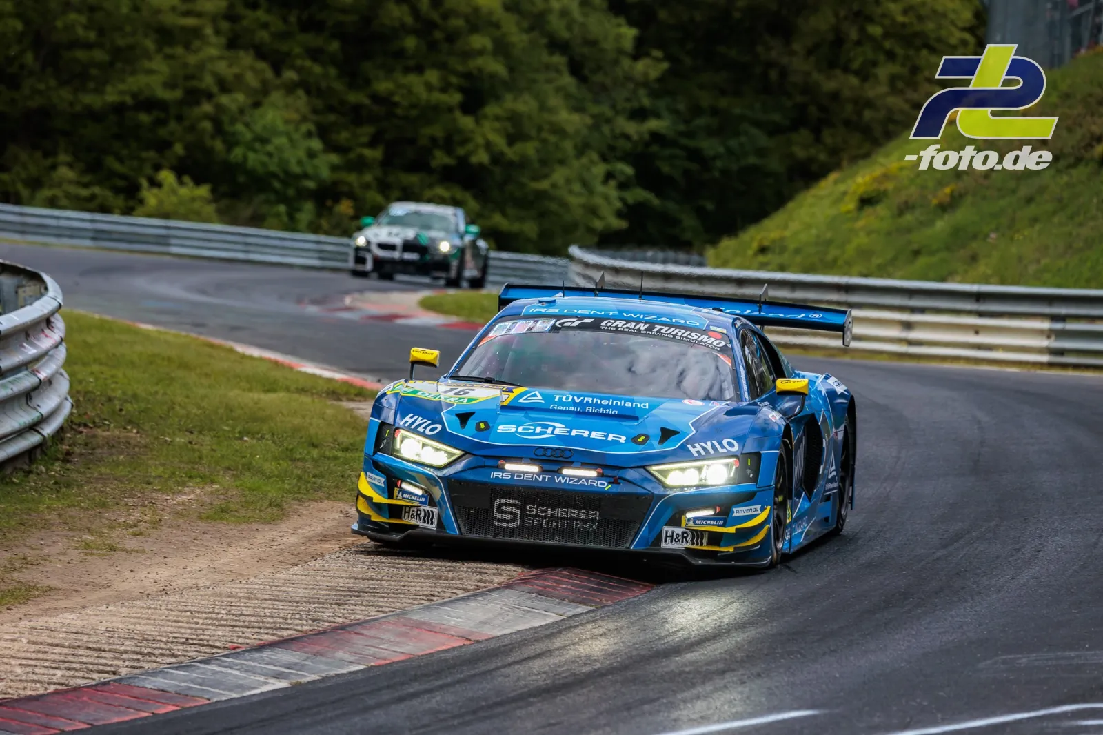 Blauer Audi R8 LMS GT3 auf der Nordschleife in Kurve, zweites Fahrzeug im Hintergrund. 24h Nürburgring 2026.
