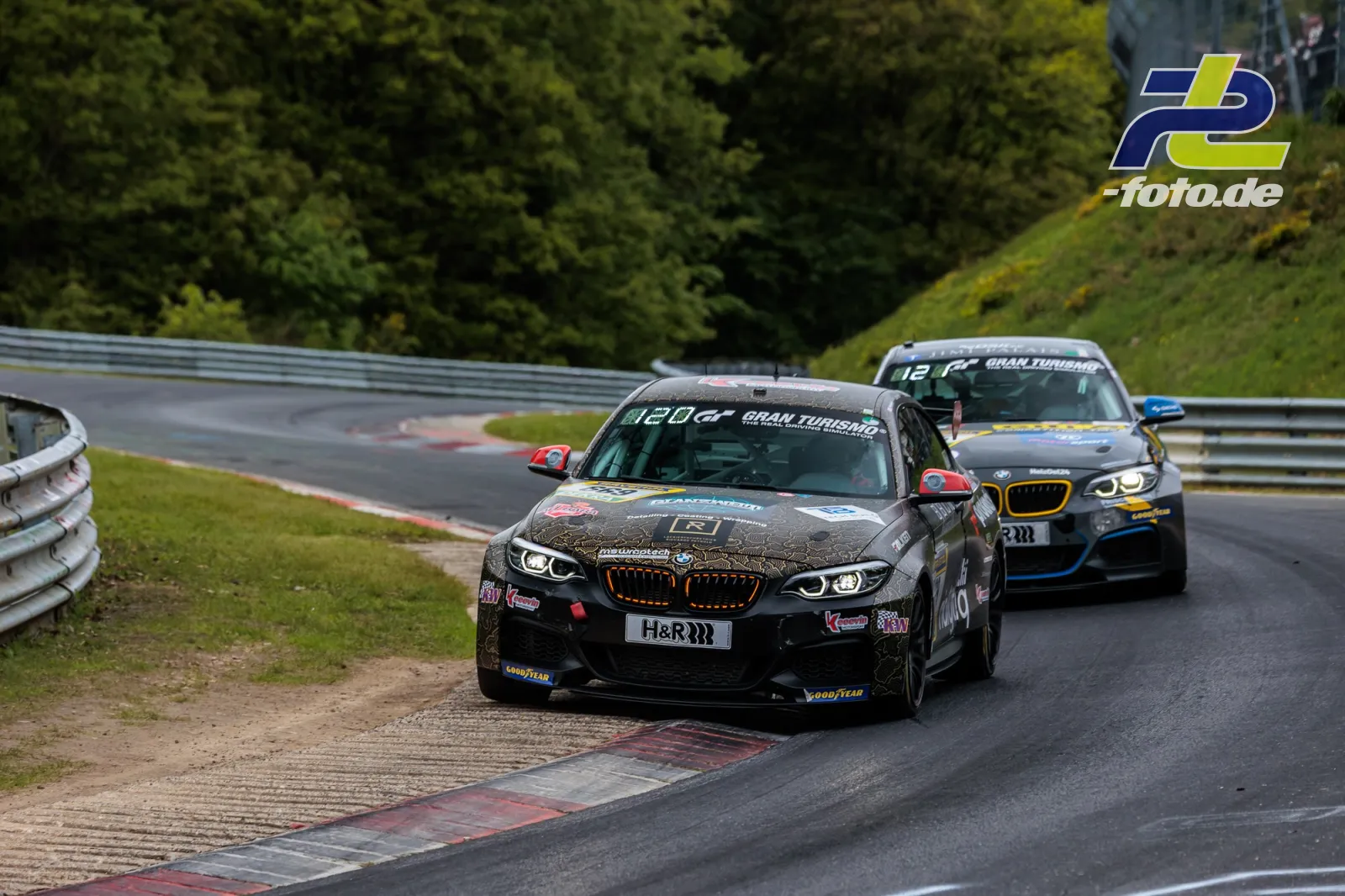 BMW M240i Racing Cup im Rennen auf der Nordschleife beim 24h-Rennen, gefolgt von einem weiteren Fahrzeug in der Kurve