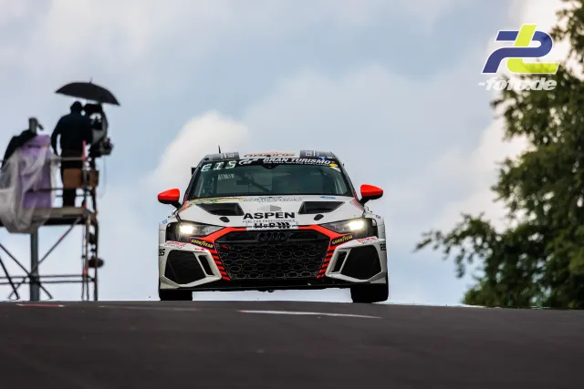 Audi RS3 LMS mit Aspen-Lackierung über der Kuppe auf der Nürburgring-Nordschleife beim 24h-Rennen, Streckenposten beobachten
