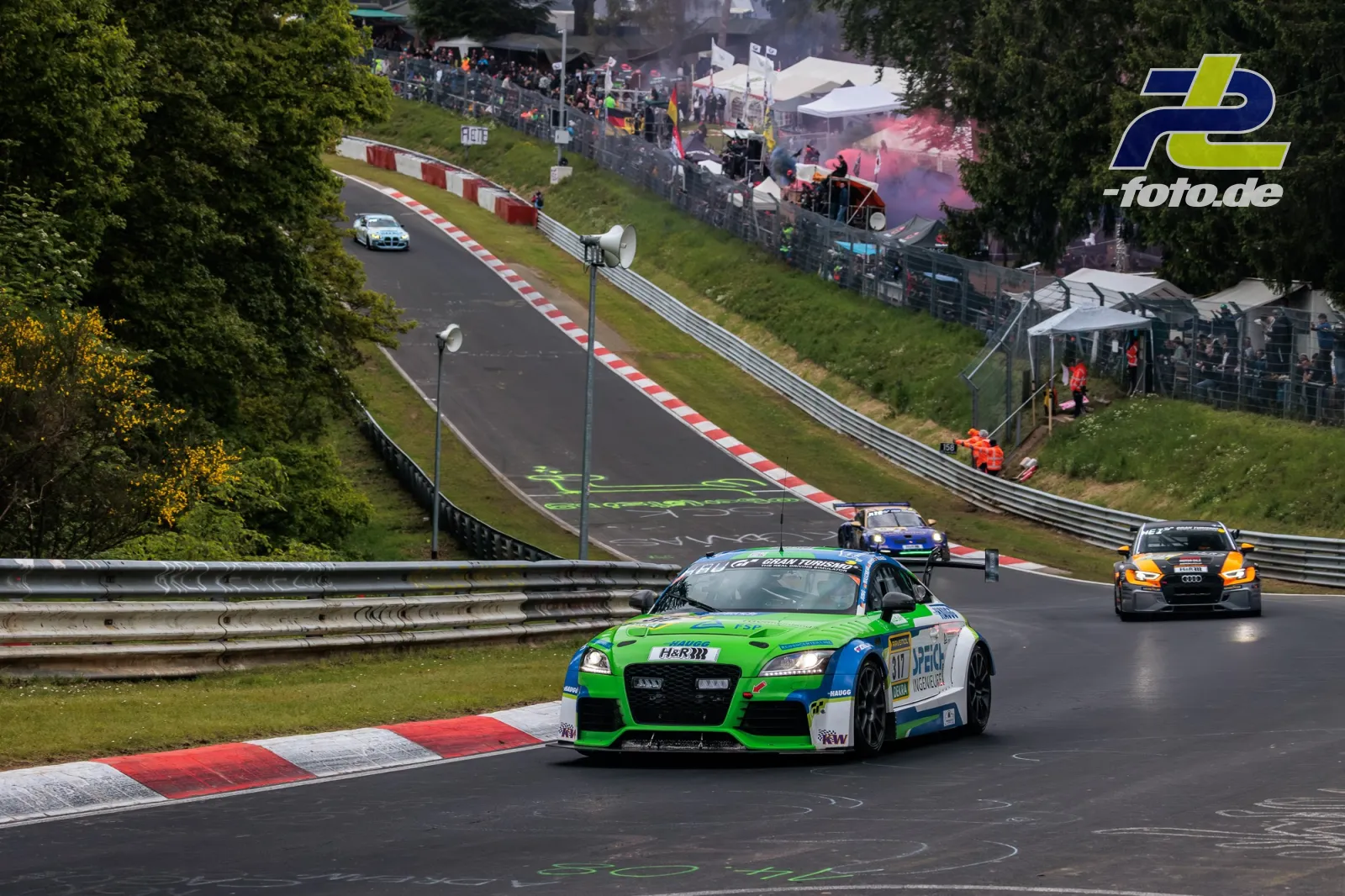 Rennwagen während der Formationsrunde auf der Nordschleife, Zuschauer und Zelte im Hintergrund, Nürburgring 24h-Rennen.