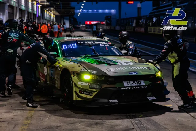 Ford Mustang #67 vom Haupt Racing Team bei nächtlichem Boxenstopp während des 24h-Rennens am Nürburgring. Mechaniker wechseln Reifen.