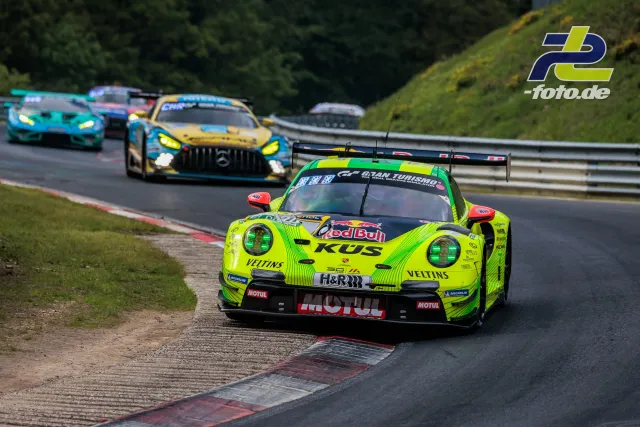 Porsche 911 GT3 R in neongelber Red Bull-Lackierung führt Feld in Kurve an, gefolgt von Mercedes-AMG und weiteren GT3-Fahrzeugen.