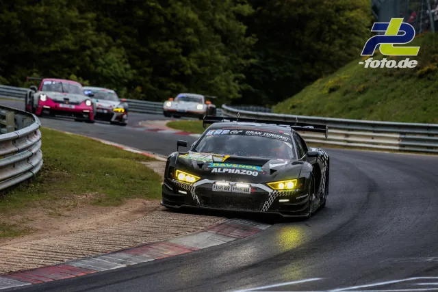 Audi R8 LMS GT3 mit gelben Scheinwerfern nutzt Randstein am Nürburgring während des 24h-Rennens.