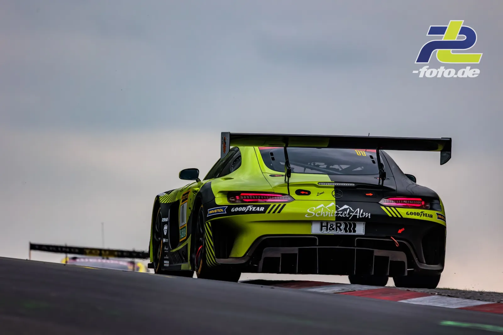 Mercedes-AMG GT3 in neongrüner Lackierung von hinten auf der Rennstrecke beim 24h-Rennen Nürburgring, großer Heckspoiler sichtbar.