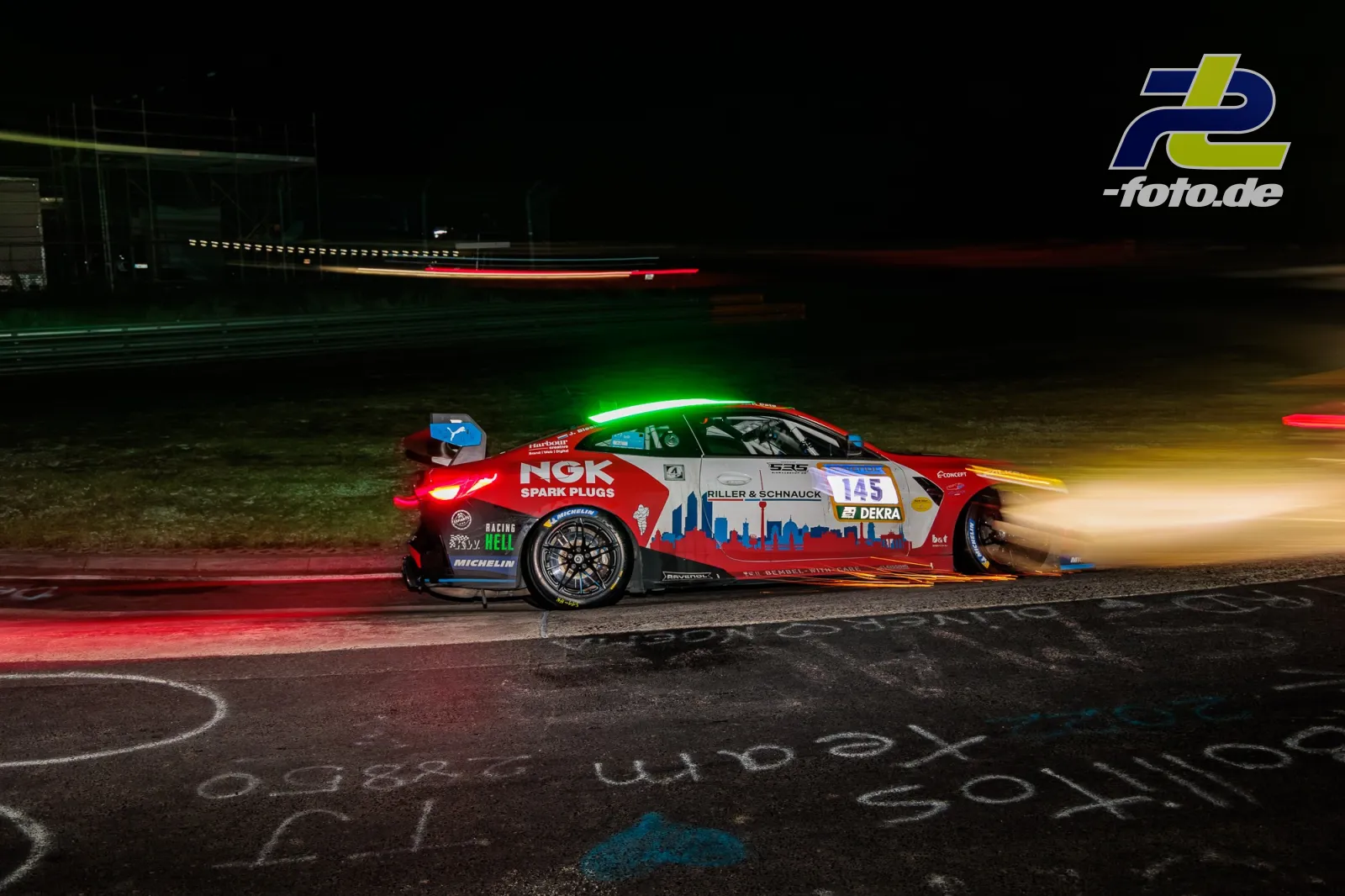 Hyundai i30 N TCR #145 bei Nacht auf dem Nürburgring, mit Langzeitbelichtung und Lichtspuren im Hintergrund während des 24h-Rennens.