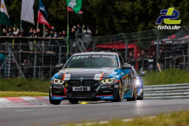 BMW M4 auf der Nordschleife während des 24h-Rennens, Zuschauertribüne im Hintergrund