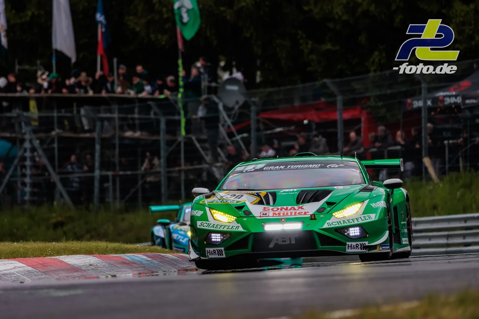 Grüner Lamborghini Huracan GT3 EVO2 #130 des Red Bull Team ABT in einer Kurve beim 24h-Rennen Nürburgring, dahinter ein weiteres Fahrzeug.