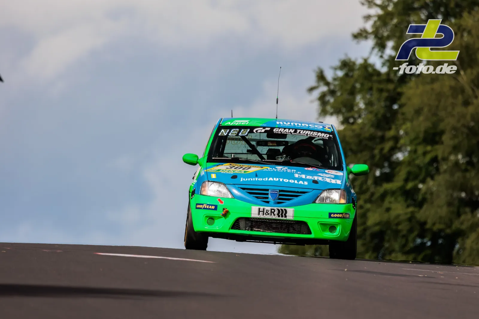 Dacia Logan springt über die Kuppe, Fahrzeug hebt vom Boden ab. 24h-Rennen Nürburgring.