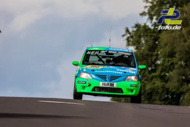 Dacia Logan springt über die Kuppe, Fahrzeug hebt vom Boden ab. 24h-Rennen Nürburgring.