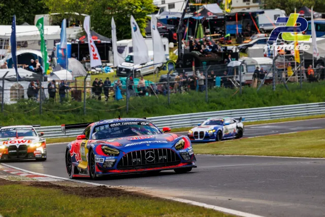 Mercedes-AMG GT3 in Red Bull-Lackierung auf der Nordschleife vor Zuschauern und Fahrerlager während des 24h-Rennens am Nürburgring.