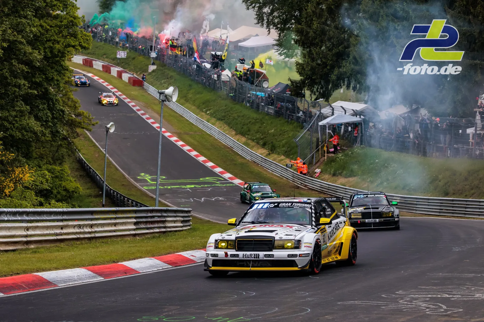 HWA EVO.R #62 während der Formationsrunde auf der Nürburgring-Nordschleife beim 24h-Rennen mit Zuschauern und bunten Rauchfackeln.