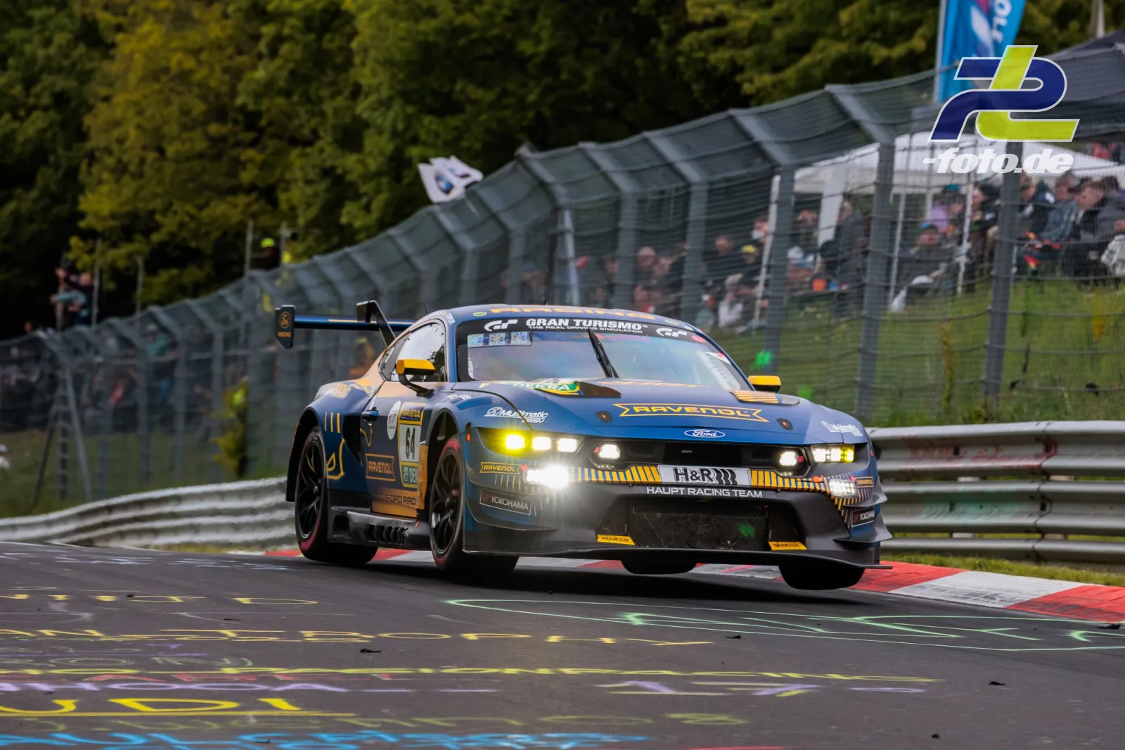 Ford Mustang SP9 des HAUPT RACING TEAM in Kurve auf der Nordschleife beim 24h-Rennen Nürburgring, Zuschauertribüne im Hintergrund.