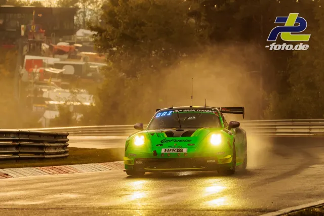 Leuchtend grüner Porsche 911 GT3 R bei nasser Strecke und tiefstehender Sonne auf der Nordschleife des Nürburgrings.
