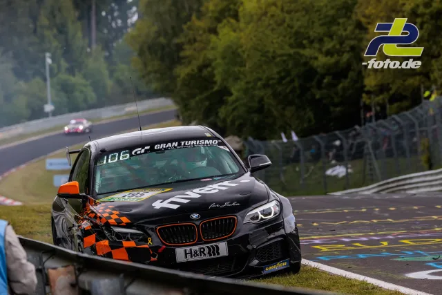 BMW mit schweren Frontschäden nach Unfall am Nürburgring, Fahrzeug steht im Gras neben der Strecke