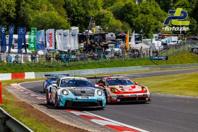 Zwei Porsche 911 GT3 R im Qualifying-Duell auf der Nordschleife, Fahrerlager und Mercedes-Banner im Hintergrund.