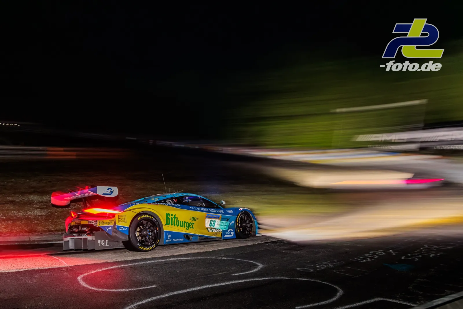BMW M4 GT3 #69 während des 24h-Rennens am Nürburgring bei Nacht in der Kurve, aufgenommen mit Mitzieher-Technik.