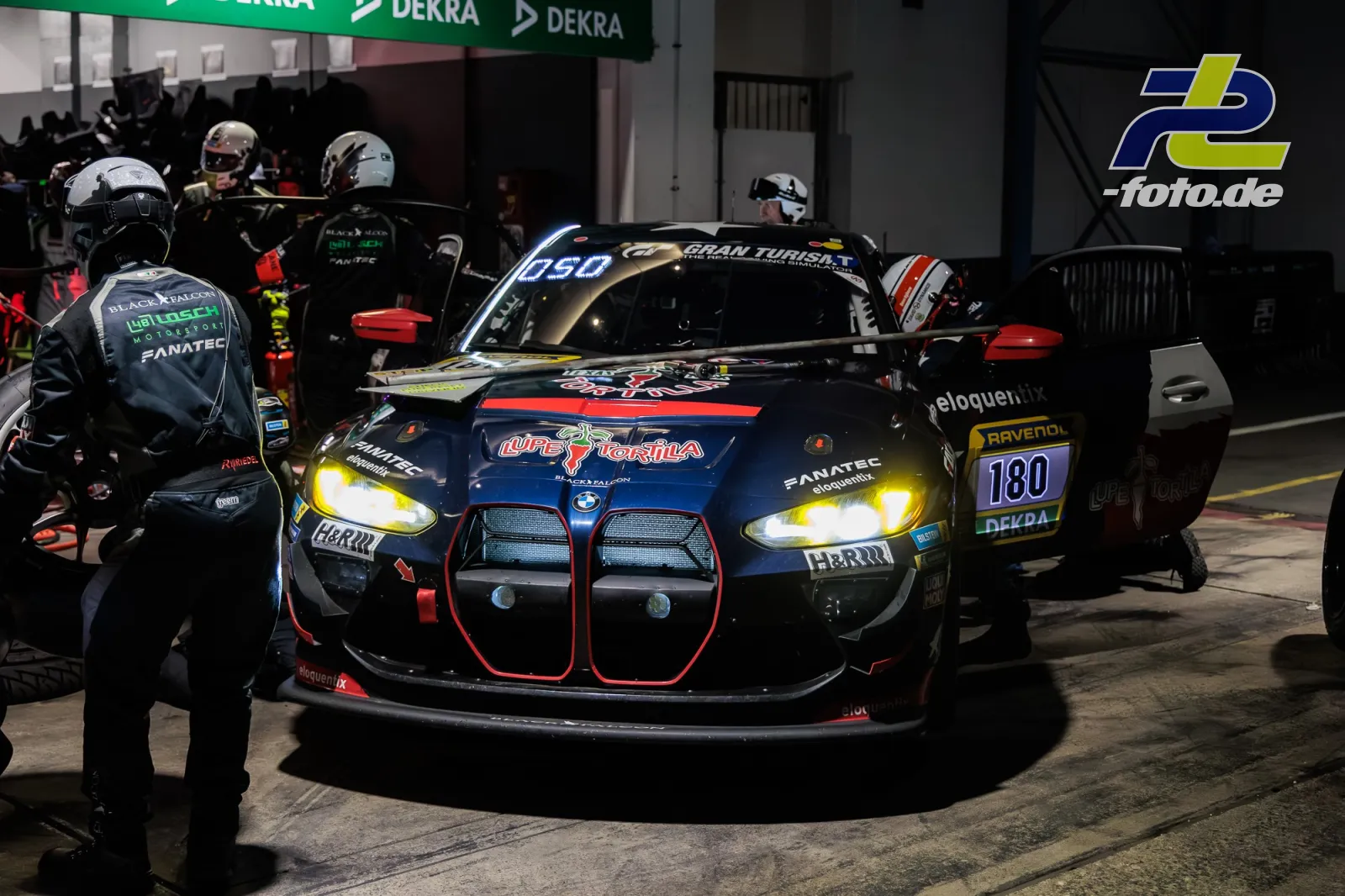 BMW M4 GT3 Nummer 180 bei nächtlichem Boxenstopp während des 24h-Rennens am Nürburgring, Mechaniker bei der Arbeit.